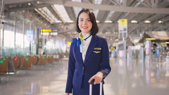 Portrait of beautiful Caucasian flight attendant staff smiling and looking at camera  in airport.