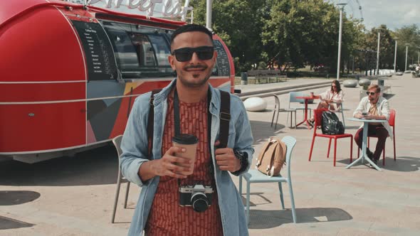 Portrait of Smiling Man with Coffee in Paper Cup Outdoors