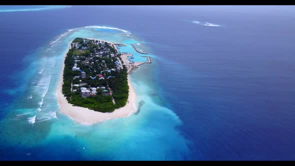 Aerial flying over landscape of beautiful tourist beach adventure by blue lagoon and white sandy bac