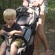 Mother rolls her son in a carriage through the summer forest. - VideoHive Item for Sale