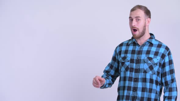 Happy Bearded Hipster Man Touching Something and Looking Surprised