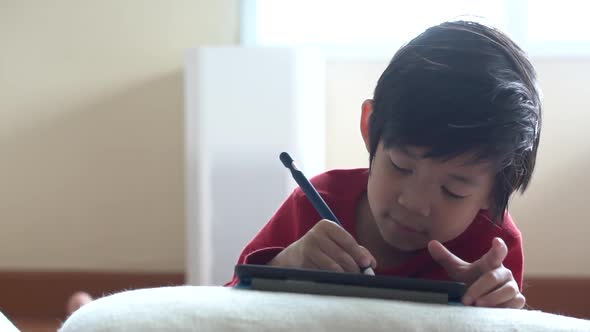 Asian Child Drawing Picture With Digital Pen On Tablet Pc Computer
