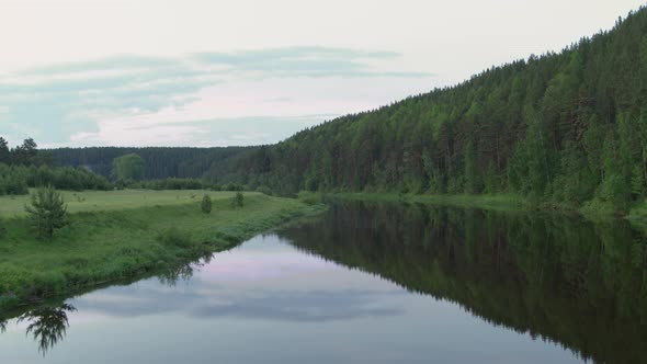 Aerial View of the River with Smooth Water and Forest on the Banks