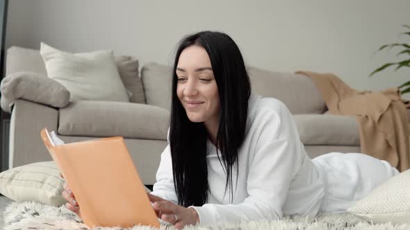 Young Beautiful Woman Reading Book Lying Floor Home