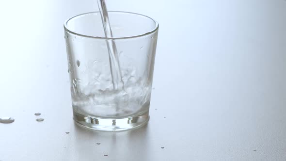 Water Is Poured Into a Transparent Glass and a Person's Hand Takes the Glass.