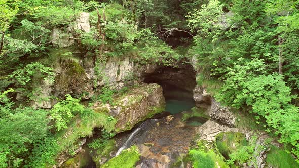 Aerial view of a waterfall surrounded by rocks and nature nearby Soca River.