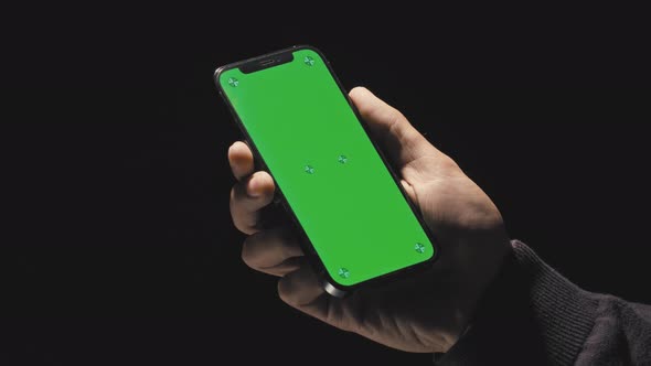 Point of View of Man on Black Background Using Phone with Green Mockup Screen Chroma Key