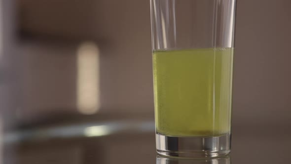 Closeup of Effervescent Tablet Dissolve in a Glass of Water Slow Motion Shot