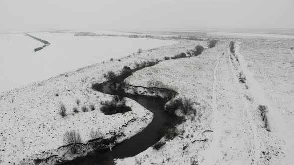 Aerial drone view of river bed, Snowy, winter time, Countryside, Zoom in