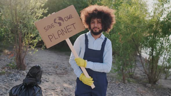 Portrait of Mixed Race Guy Eco Activist Looking To Camera While Standing with Carton Placard