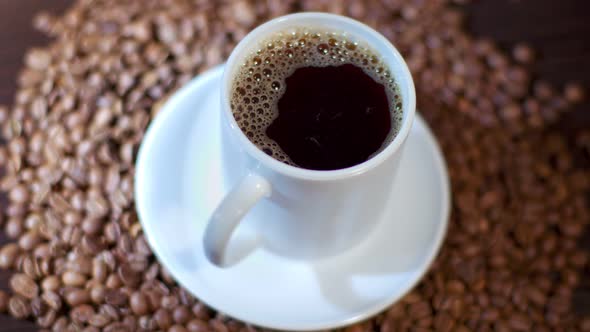 A White Mug Filled with Dark Black Coffee Being Cooked in a Coffee Shop