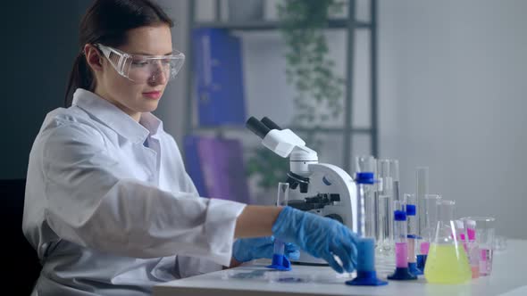 Female Chemist is Working in Modern Chemical Laboratory Experimenting with Reagents