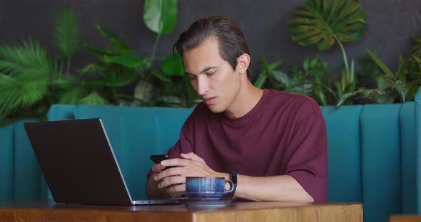 Man Working on Laptop in Cafe