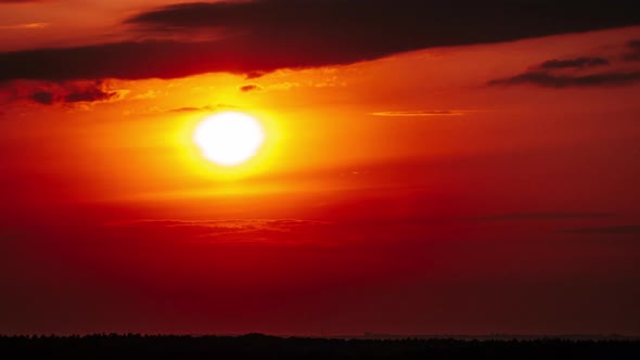 Timelapse Dramatic Sunset with Sun Rays in the Sky Through Orange Layered Clouds