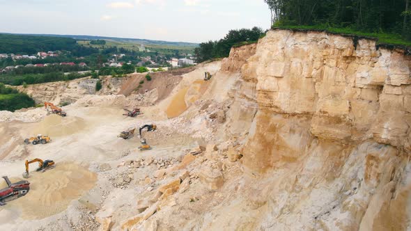 Excavator Working in a Sand Quarry and Extracting Sand, An Excavator Picks Up Sand with a Bucket and