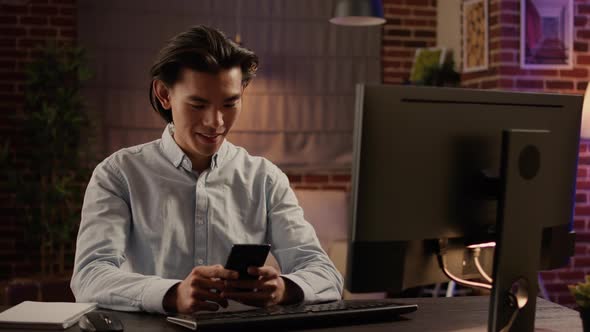 Asian Man Browsing Internet on Smartphone and Texting Messages