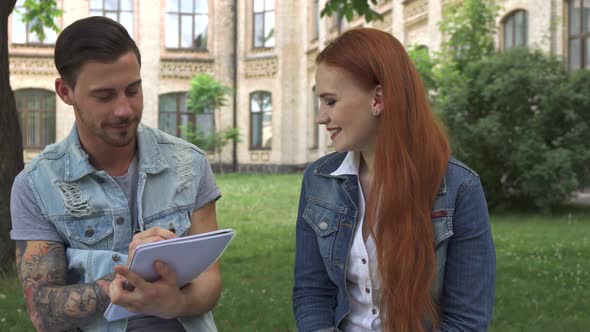 Male Student Notes What His Classmate Says