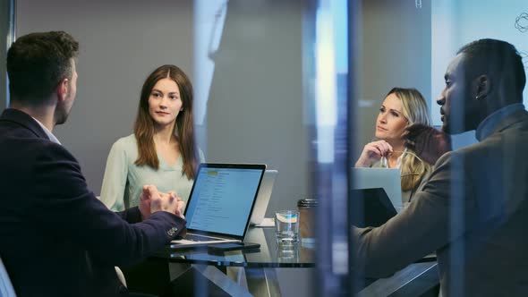 Entrepreneurs with laptops in meeting talking business