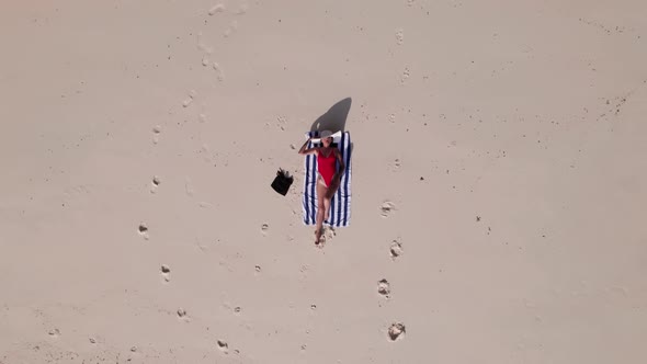 Drone Of Woman Sunbathing In Swimsuit On Entalula Beach