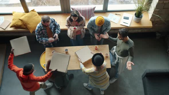 Top View of Joyful Coworkers Bringing Pizza to Office Enjoying Delicious Food Clapping Hands