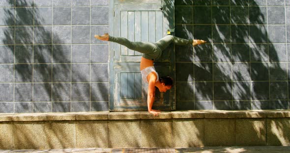 Young ballerina dancer practicing handstand against wall 4k