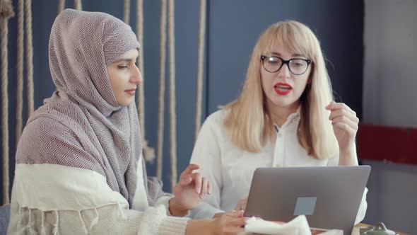 Businessowomen Having a Conversation in a Cafe