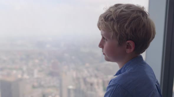 Boy Looking Through Skyscraper Window To New York City