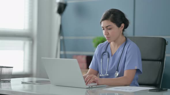 Indian Female Doctor having Back Pain while using Laptop in Office