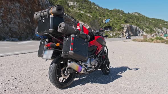 Motorbike with Motorcycle Cases Stands Against Mountain Landscape of Montenegro