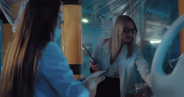 Beautiful Women Scientists Discuss Conducting a Scientific Experiment in a Space Laboratory