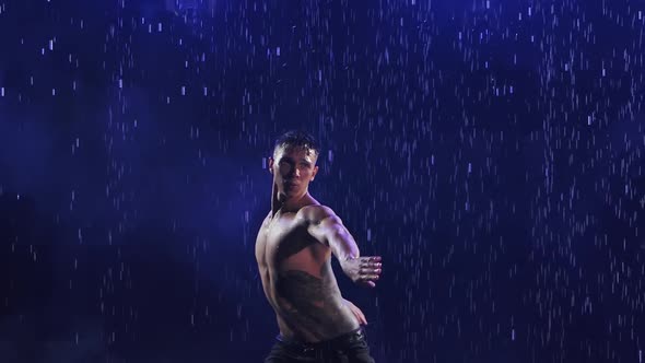 Sexy Young Man in Wet Jeans Emotionally Dancing Modern Ballet Dance in the Rain. Contemporary