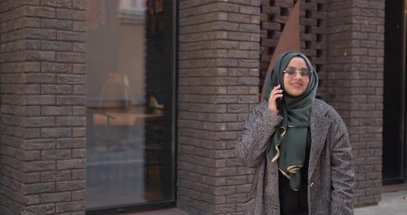Muslim Woman in Veil Talking By Phone Outdoors