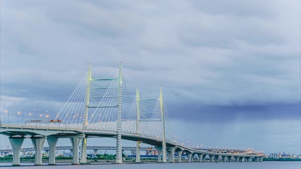 Timelapse of a Large Modern Bridge with Moving Cars in the Evening Against the Background of Rainy