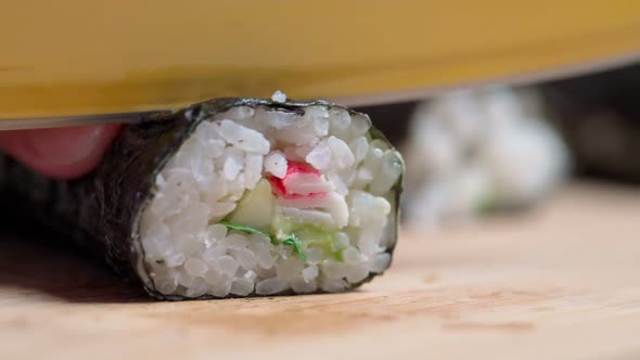 The Chef Cuts Sushi and Rolls Made From Seafood with Asian Ingredients with a Knife