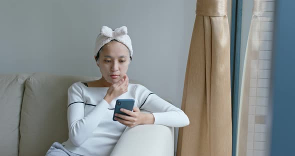 Woman use of smart phone with paper mask at home