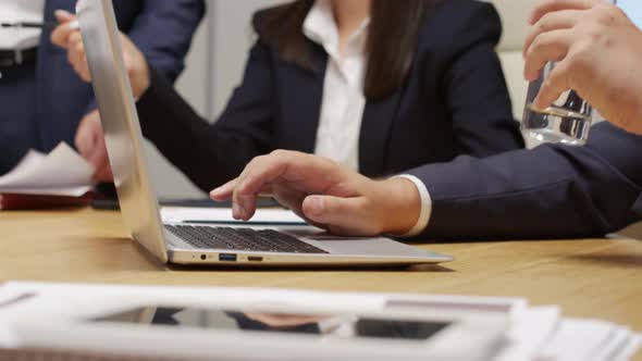 Unrecognizable Businessman Drinking Water and Working in Meeting