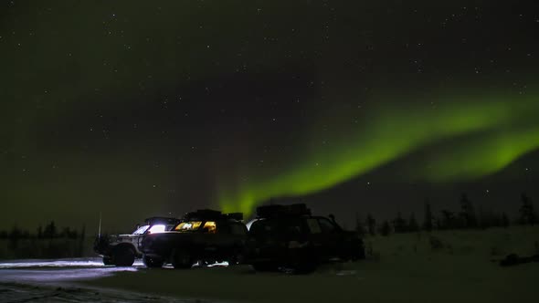 Three cars under the Arctic sky in Syberia, Yakutia, Time lapse of Northern Lights Aurora Borealis