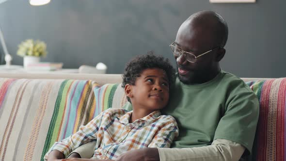 Portrait of Happy Afro Father and Son on Sofa at Home