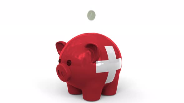 Coins Fall Into Piggy Bank Painted with Flag of Switzerland alt