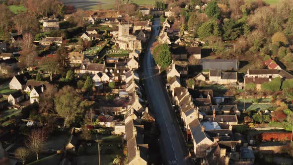 Aerial drone video of a Cotswolds Village, a rural scene in English countryside with houses, propert