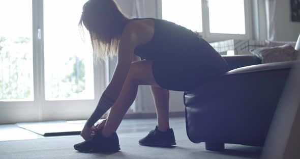 Tattooed Sporty Woman Tying Her Shoes Before Fitness Workout at Home