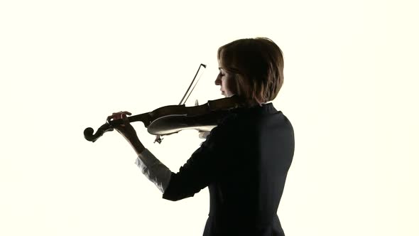 Girl Performs on a Violin in a White studio.White Background. Slow Motion