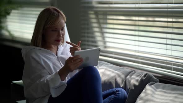 Young Woman Is Chatting Online By Internet on Tablet, Resting at Home in Weekends