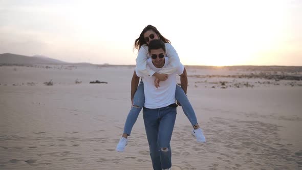 Happy and Cute Adorable Adult Couple in White Shirts and Jeans Man with Woman Girlfriend on Piggy