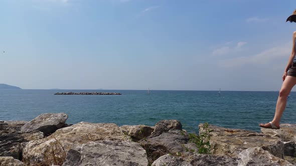 Young woman walking on rocks near the sea