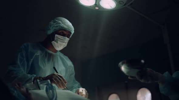 Serious Surgeon Performing Surgical Treatment in Ward