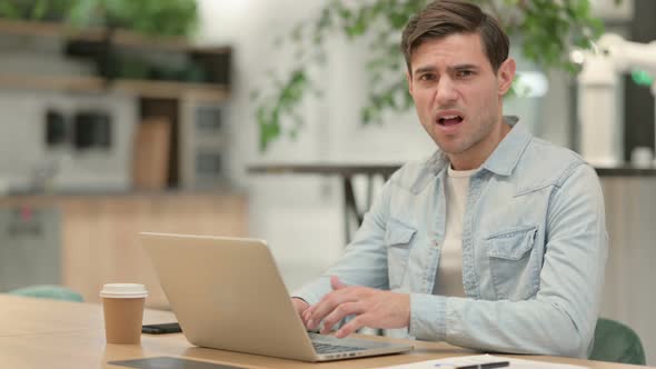 Creative Young Man with Laptop Feeling Shocked