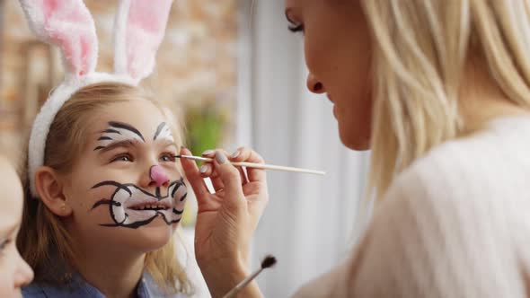 Video of mom painting Easter bunny on her daughter's face. Shot with RED helium camera in 8K