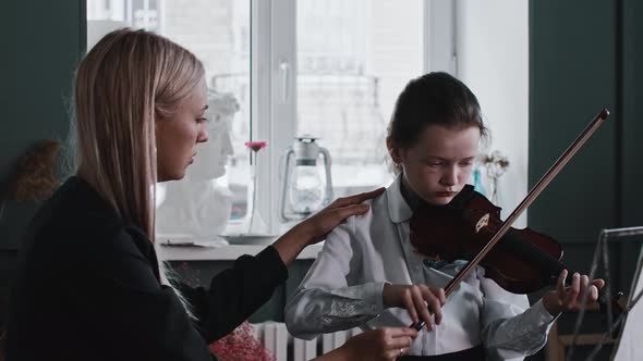 A Girl Playing Violin During Lesson with Blonde Young Woman Teacher