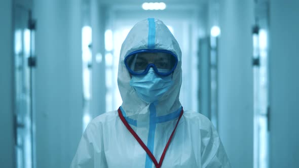 A Woman Looks at Camera, While Wearing Protective Suit.